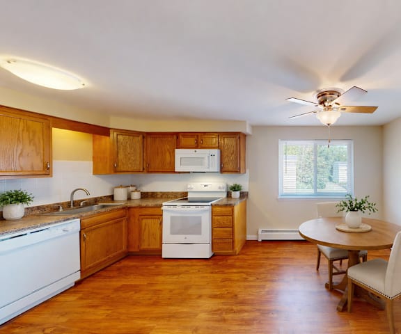 A kitchen with wooden cabinets and a white stove top oven.