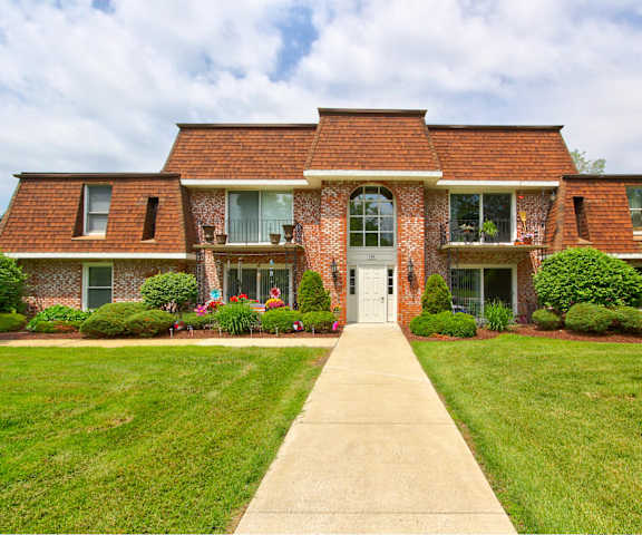a large brick house with a sidewalk in front of it