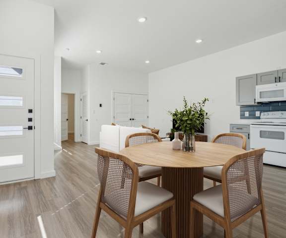 A modern dining room with a wooden table and chairs.