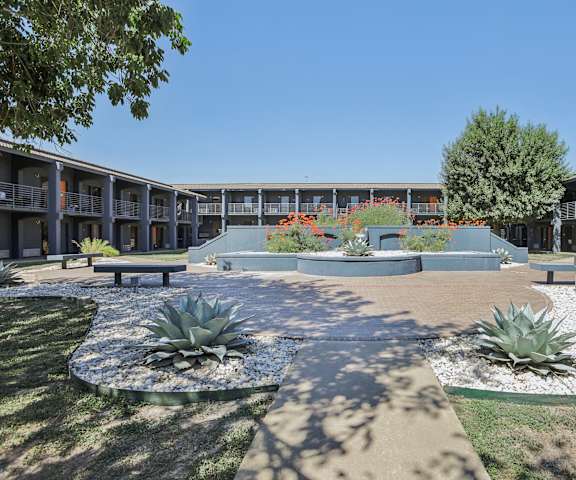 a courtyard with benches and plants in front of a building