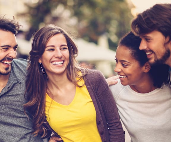 A group of people are standing together and laughing.