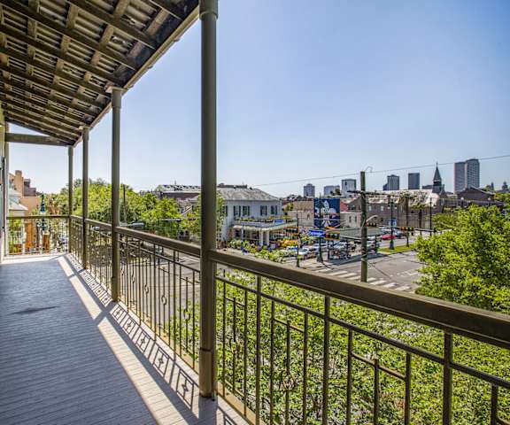 A balcony with a metal railing and a view of a city skyline.