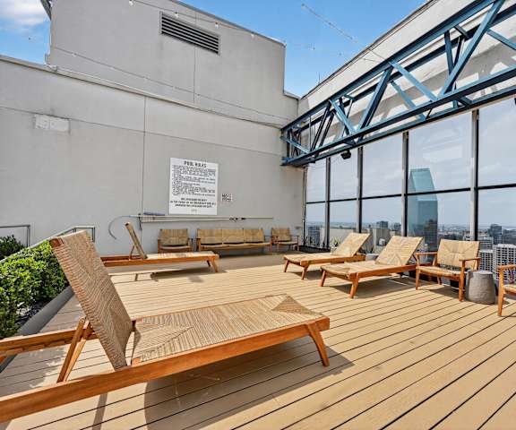 A wooden deck with chairs and a sign on a building.