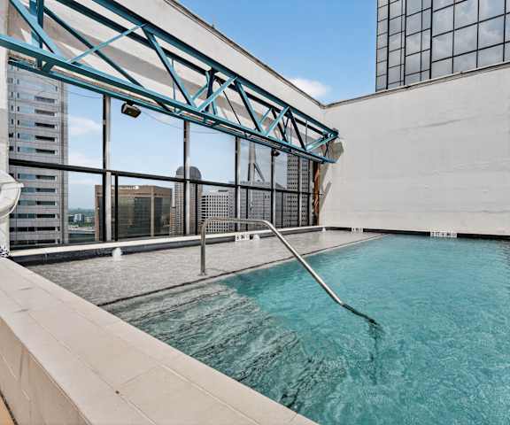 A swimming pool on a rooftop with a city view.