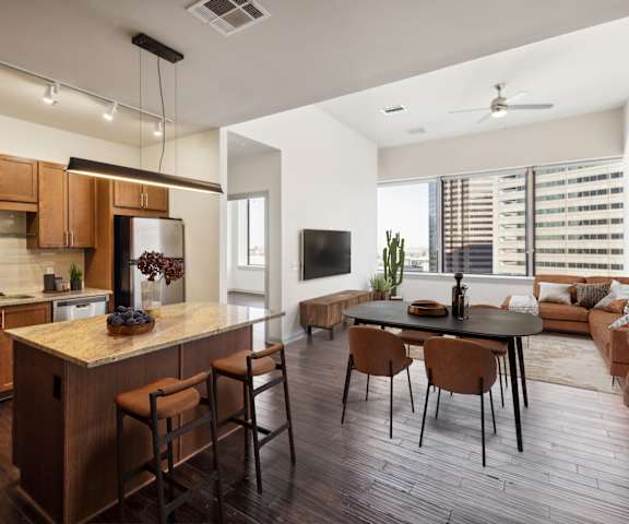 A modern kitchen with wooden cabinets and a bar area.