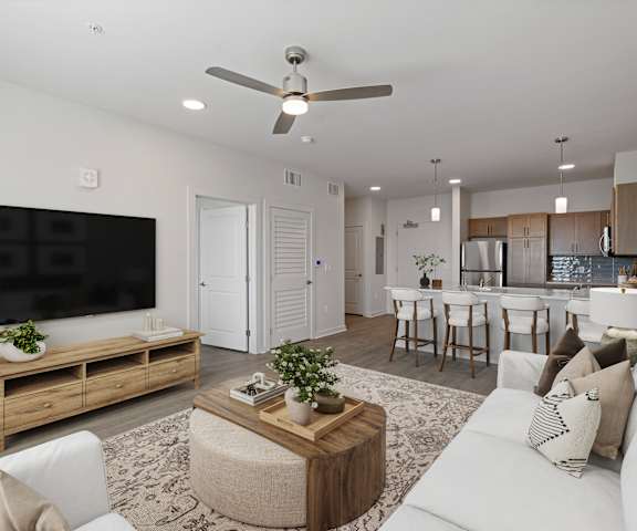 A modern living room with a white sofa, wooden coffee table, and a flat-screen TV.
