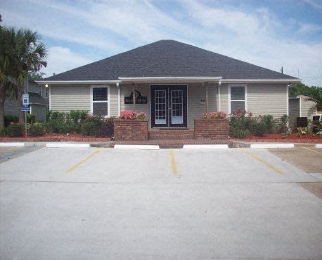 A small building with a parking lot in front.