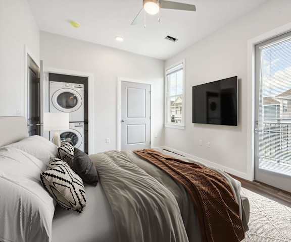 A bedroom with a large bed and a flat screen TV mounted on the wall.