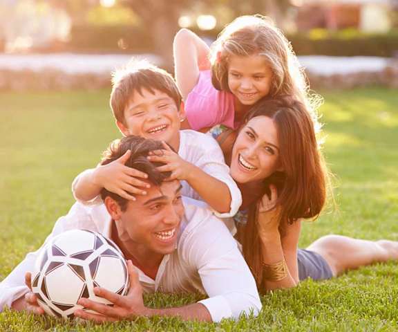 Family of four playing soccer 