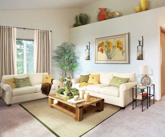 A living room with a white couch, a coffee table, and a painting on the wall.