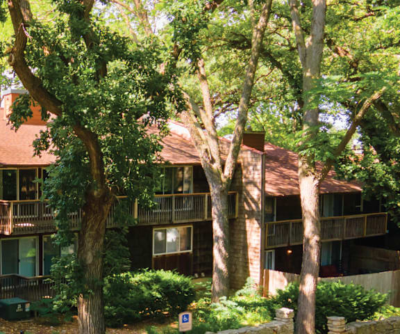 a cabin with a deck and trees in front of it