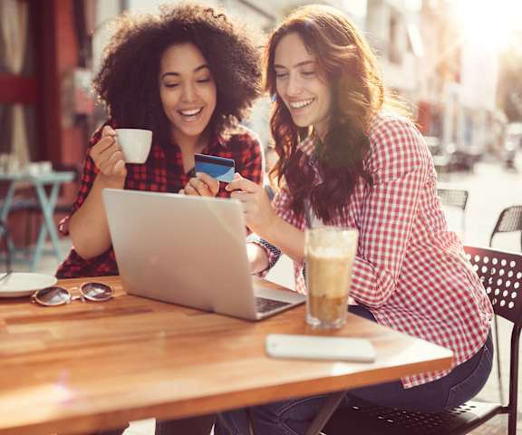 stock image- friends with laptop drinking coffee in café
