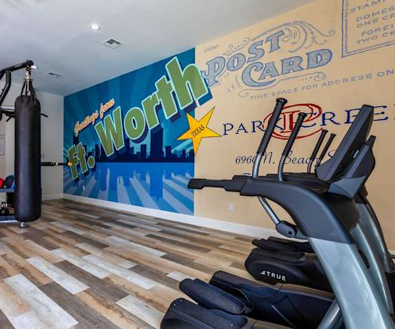 a home gym with a wall mural and exercise equipment