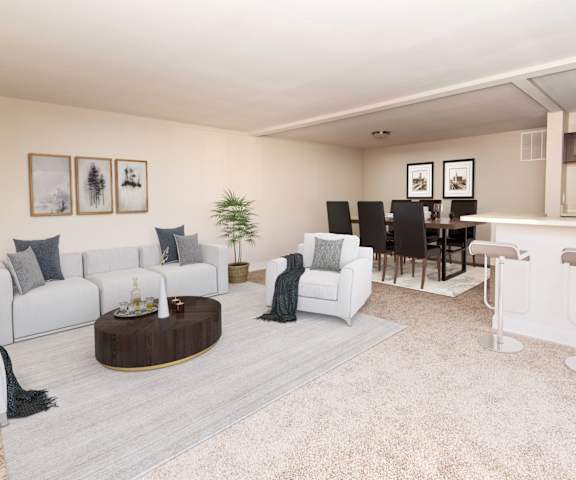 a living room with white couches and chairs and a bar with stools at Stevenson Lane Apartments, Towson MD