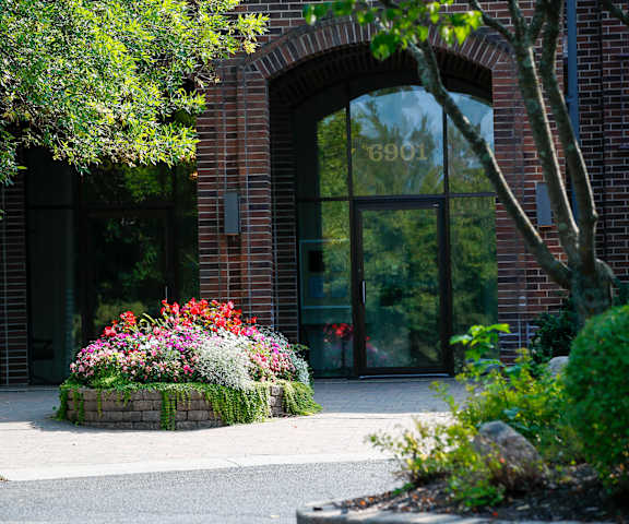 the front of a building with a flower garden in front of it