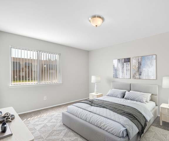 A bedroom with a large bed and two lamps.
