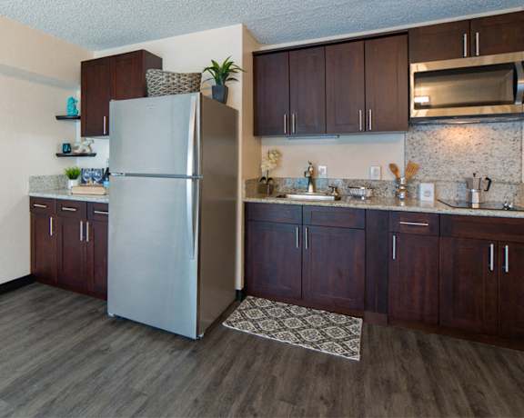 Waikiki Walina Apartments kitchen area with appliances, cabinets, and counters