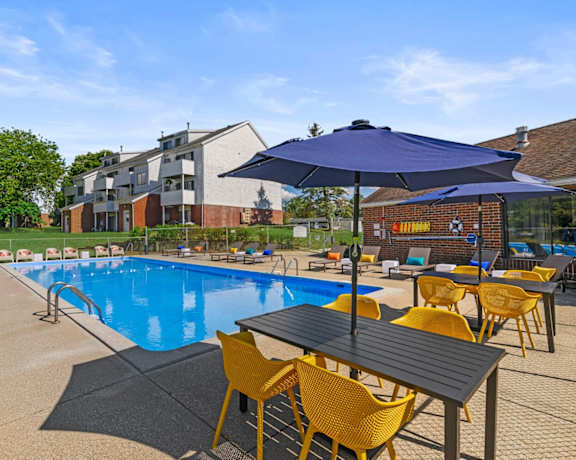 our apartments have a pool and patio with chairs and umbrellas