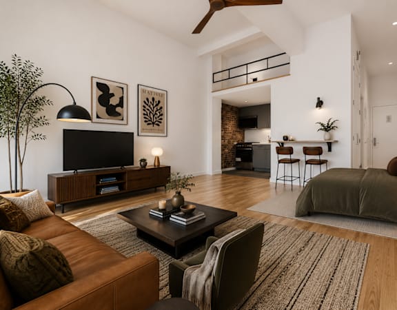 A living room with a brown leather couch and a television on a wooden stand.