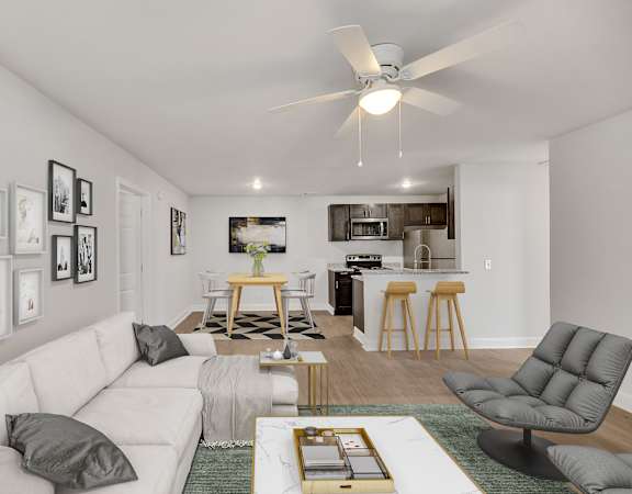 a living room with a white couch and a kitchen in the background