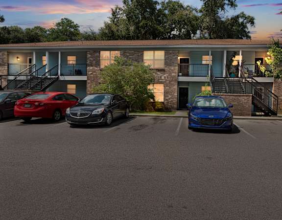 a parking lot with three cars in front of a building
