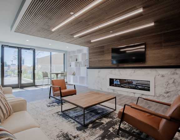 a living room with a couch and a table and a fireplace at The Rail at Red Bank, New Jersey