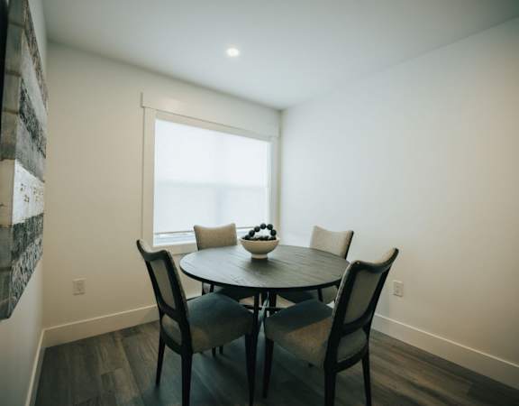A dining room with a table and chairs.