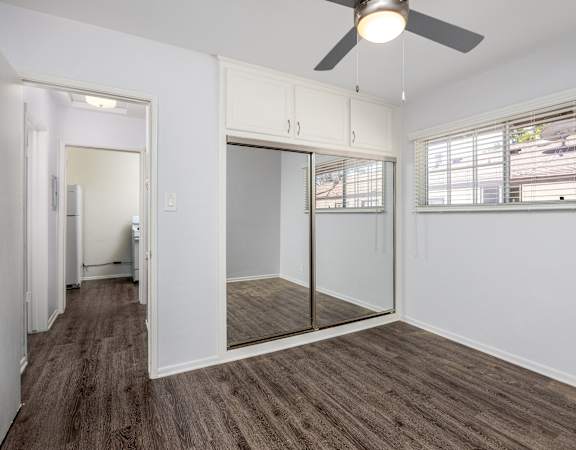 an empty room with a window and a ceiling fan
