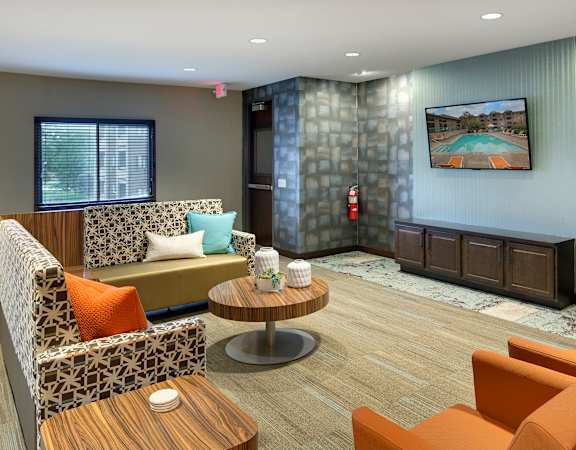 A room with a couch, chairs, and a coffee table.