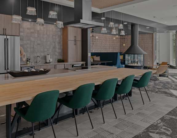 a kitchen with a long wooden table and green chairs