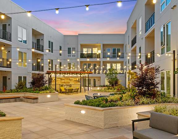 a courtyard with seating and a fire pit at the preserve at great pond apartments in windsor