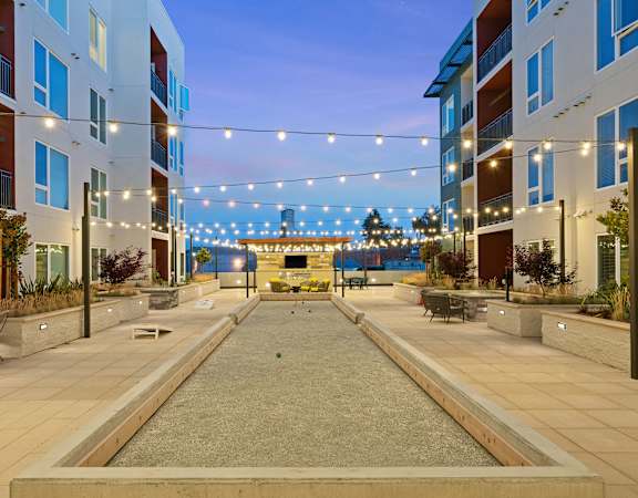 a courtyard with a fountain and string lights at the flats at big tex apartments in san an
