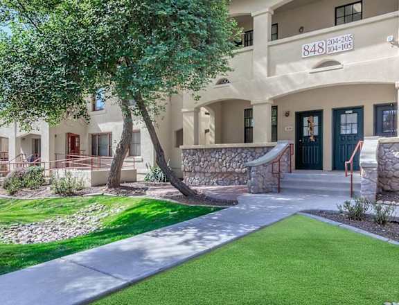 the front of a building with a yard and grass