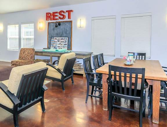 a dining room with a table and chairs and a rest assured sign on the wall