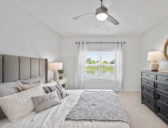 a bedroom with a large bed and a ceiling fan