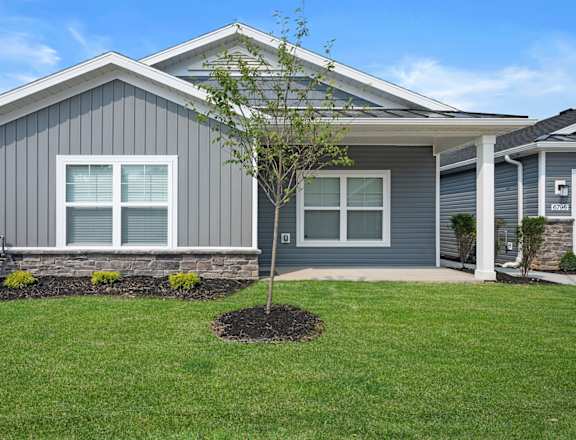 a home with a tree in the front yard