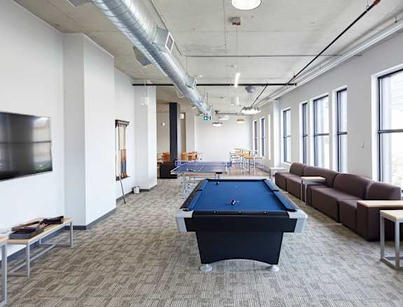 A room with a pool table and a television.