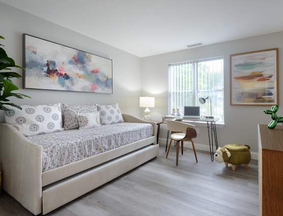 a bedroom with a bed and a desk with a computer