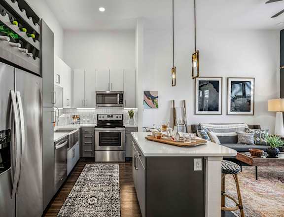 an open kitchen and living room with stainless steel appliances