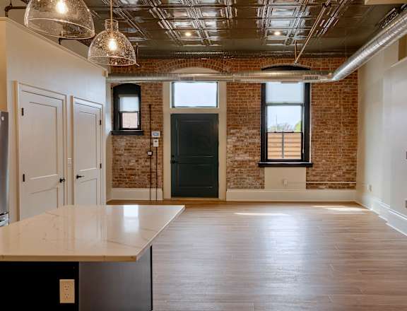 A large open room with a brick wall and a long counter.