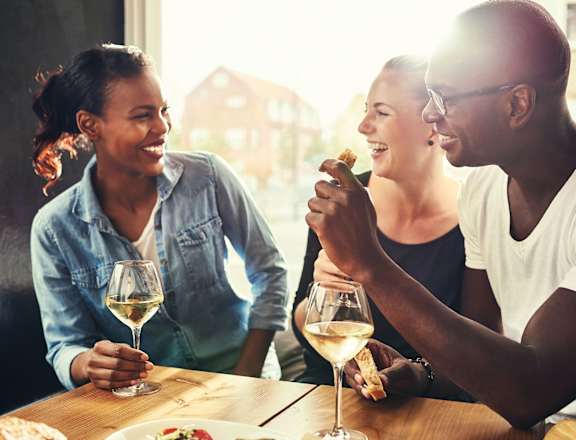 Group of young professional friends laughing and socializing with wine at The Metropolitan in Bethesda, MD.