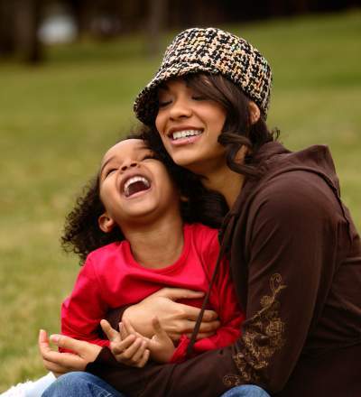 a woman and a child sitting on the grass