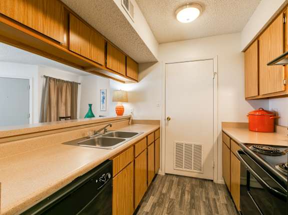 A kitchen with wooden cabinets and black appliances.