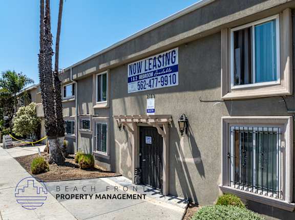 A building with a sign that says "Now Leasing" and a phone number.
