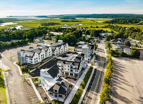 arial view of a large housing complex with green fields in the background