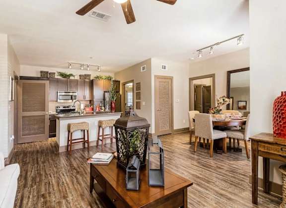 A modern living room with a kitchen in the background.