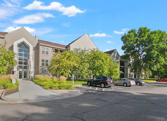 a parking lot with cars in front of a building