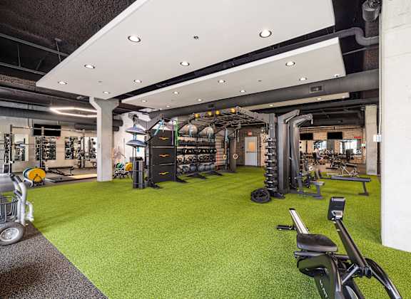 a gym with weights and exercise equipment on a green carpet at EagleRidge Plaza Residences, Fargo, 58104