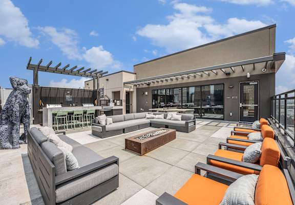 a rooftop patio with couches and a fire pit