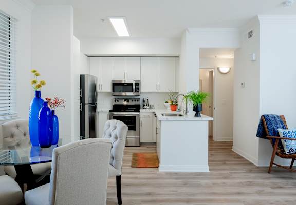A modern kitchen with a dining table and chairs.